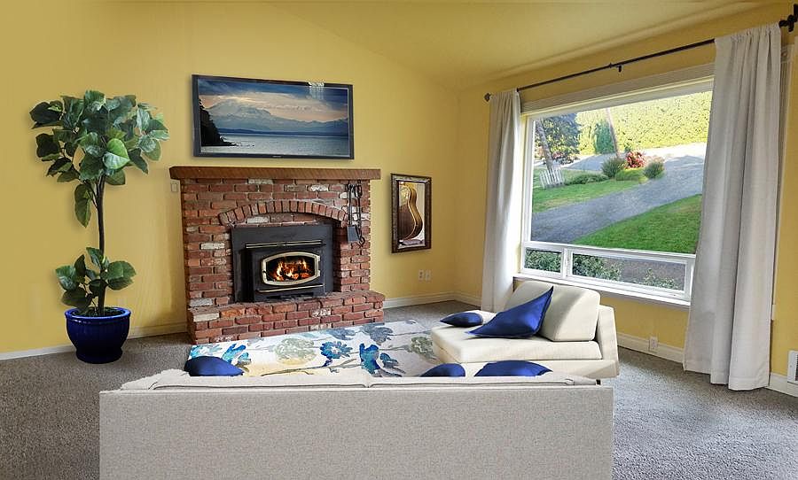 Living room with fireplace and large picture window where you will see beautiful sunsets