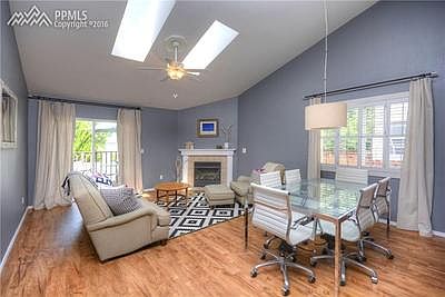 Spacious great room with a gas fireplace, vaulted ceiling, skylights, and walkou