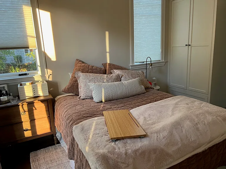 Master bedroom with vaulted ceiling, dual built-in closets, and garden-facing sliding door looking South.