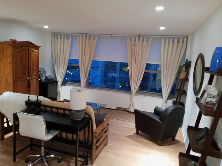 A room with a view (from the entry). Living room with home office desk, sofa and leather chair all facing the lake and marina.