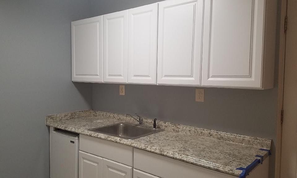 Kitchen Area, equipped with a small refrigerator, a stove, & microwave. (Picture taken before installation)