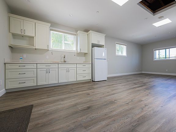 Shared great room with refrigerator, sink and cabinets