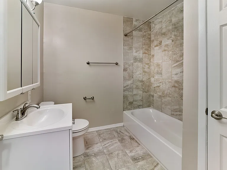 Freshly updated bathroom with stylish tile and sleek finishes at Maple Grand Apartments in Maple Shade, NJ.