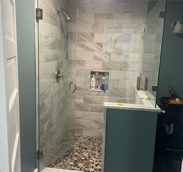 Fully remodeled oversized tile shower with river rock floor and beautiful glass basin sink.