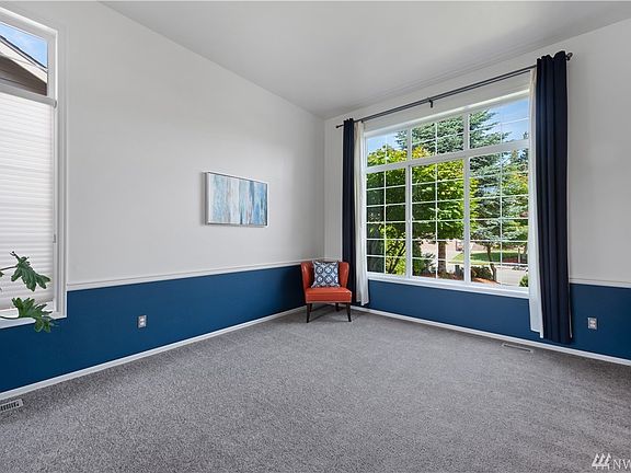 This bright formal living room invites you and your guests in with arched doorways, vaulted ceilings, over-sized windows, and chair rail.