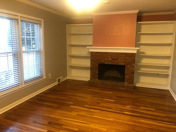 Wood burning fireplace in the living room with built in cabinetry. Beautiful hardwood floors downstairs. .