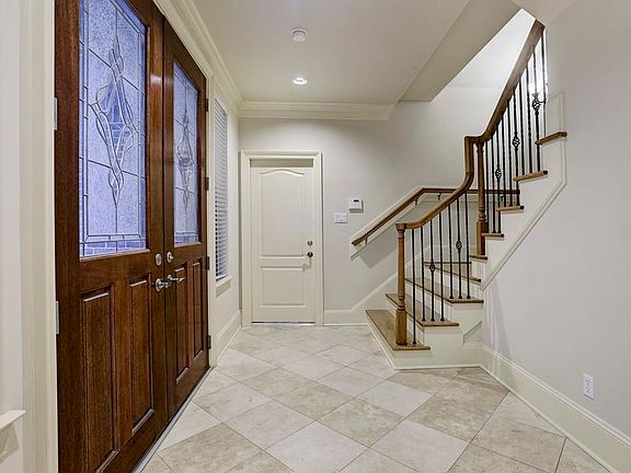 Beautiful tiled entry way showing off double front doors with lead glass.