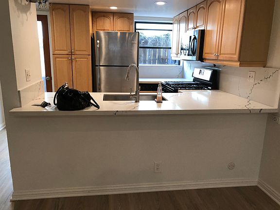 Kitchen with new stove, countertops and backsplash. Back patio accessible from kitchen