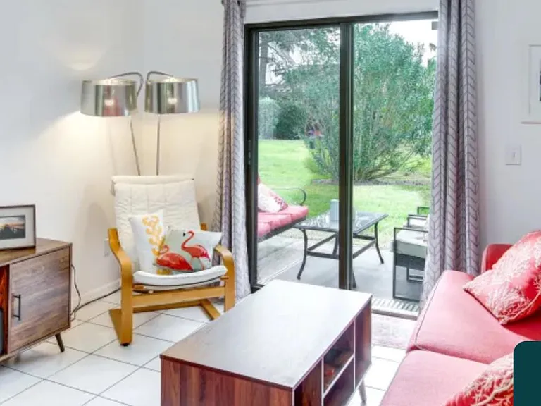 Living area leads to the back patio leads straight and right a few steps to the beautiful community pool