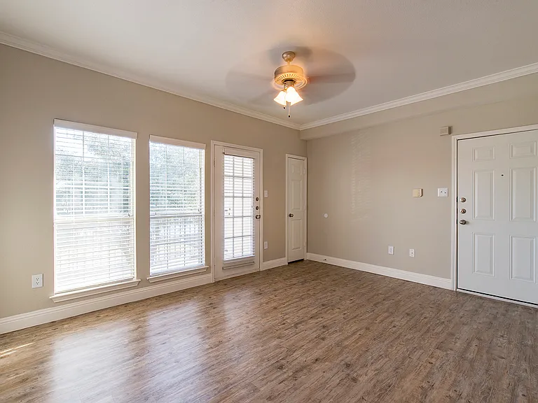 Spacious living area with wood-style flooring and natural light