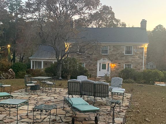 Front yard stone patio with view of 1930 2-story stone house with excellent exterior lighting.