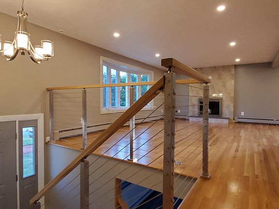 Open concept living and dining areas have new hardwood floors. Fireplace has glass doors and a tile surround.