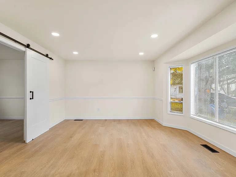 Bright living room with large windows and an office/bonus room conveniently located adjacent to it.