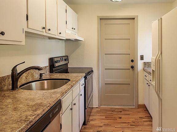 Kitchen is bright and cozy, freshly painted and leads to the garage