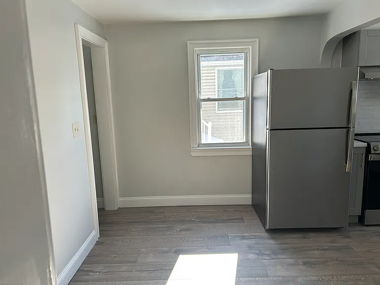 Kitchen and view of hallway that consists of a large closet and rear door entrance