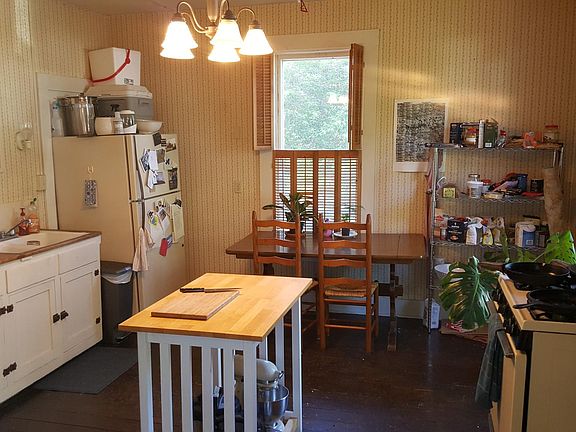 View of eat-in kitchen from private rear entry, 10' ceilings, gas stove/oven, interior wooden shutters, hardwood floors