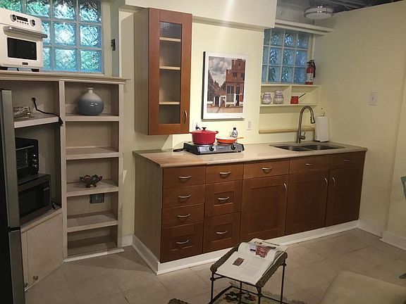 The well-equipped kitchen includes wood cabinets, granite counter, stainless steel double sink with spray faucet, Insignia refrigerator with freezer, Cuisinart induction cooktop with pans, Hauswert air fryer which roasts and bakes (yes you can roast a 3+l