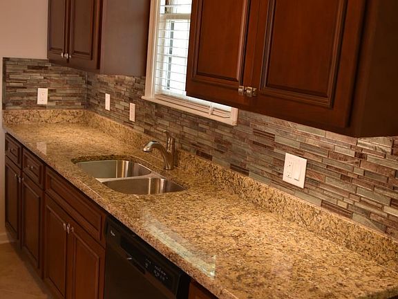 Under-cabinet LED lights, glass tile backsplash, cherry cabinets, multiple outlets