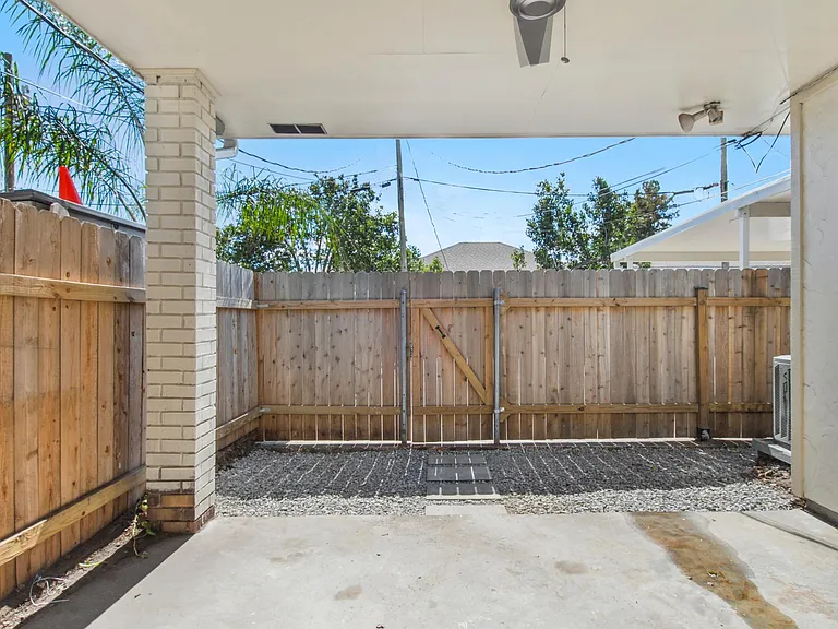 Fenced in backyard with freshly laid limestone. Brand new remote control fan for outdoor dining. Two reserved parking spaces behind the fence.