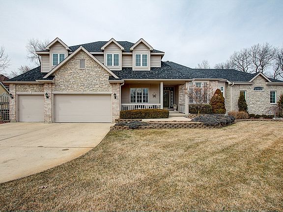 Custom Built home that features a three plus heated garage with extra storage, concrete driveway, inground heated salt water pool surrounded by custom concrete patio, pool house, landscaped professionally, maintenance free decking and fencing.