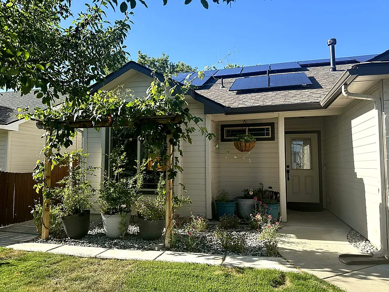Front porch with grape trellis and potted flowers for the pollinators