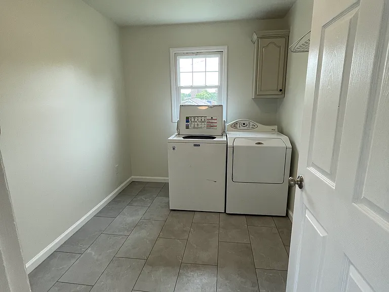 Laundry room also has space for storage shelves.