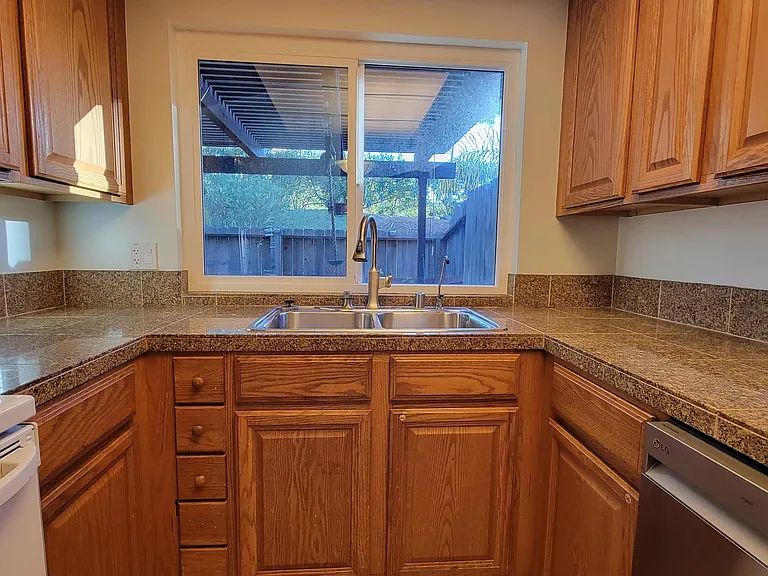 The kitchen overlooks the patio. There is a ledge right outside the window for plants and flowers.