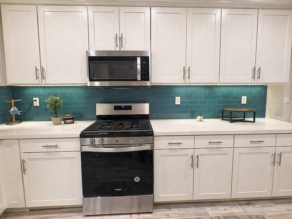 Modern white kitchen with teal backsplash