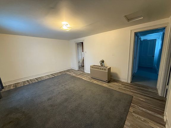 Living room and entrance to kitchen on left and hallway on right which leads to bedroom 1, laundry and the bathroom
