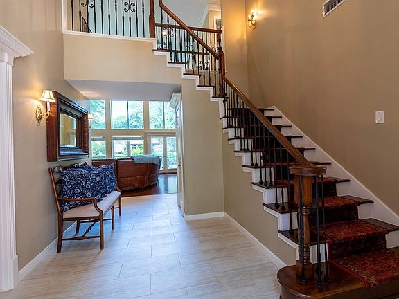 Bright foyer. Hardwood stairs with custom carpet runner.