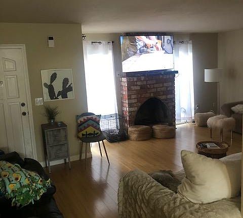 Fireplace with front door and windows looking out at green belt.