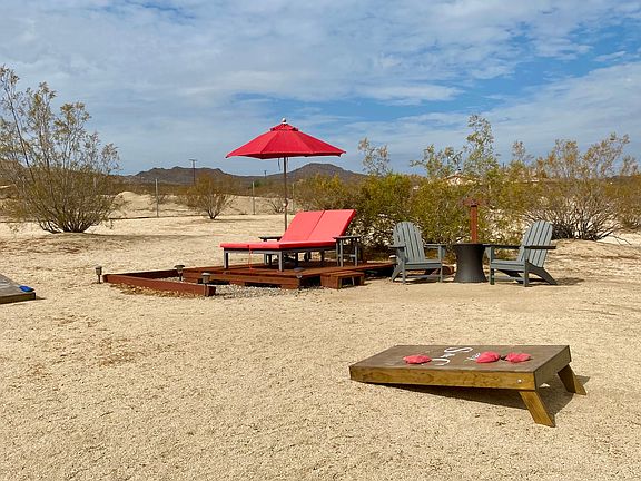 Backyard with cornhole and chaise lounges