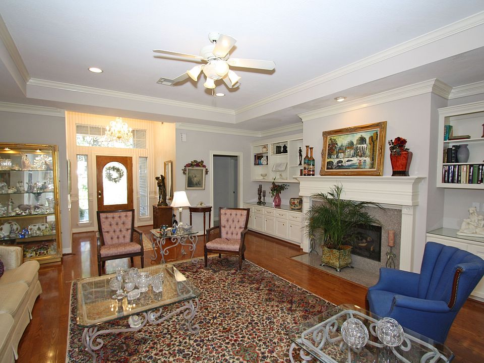 Wood floors extend into the den with firepalce, high ceilings, and built-ins.