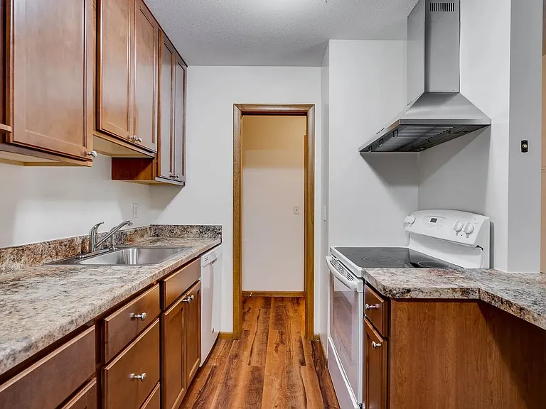 Welcome to Central Lakes of Uptown, where modern living meets comfort. This stylish kitchen features rich wood cabinetry and sleek granite countertops, perfect for culinary creations. Elevate your lifestyle today and schedule a tour!