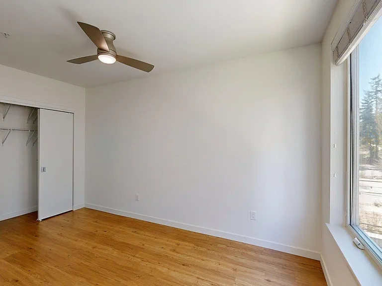 Spacious apartment Bedroom with Wood-Style Flooring.