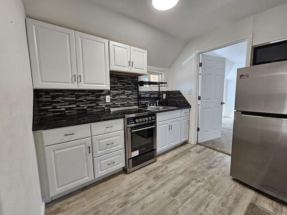 Updated kitchen with tile backsplash, stainless appliances, and lifeproof flooring