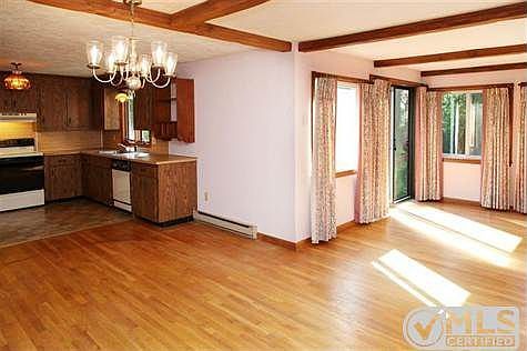 Family room with hardwood flooring, beamed ceiling, dining area and slider to patio