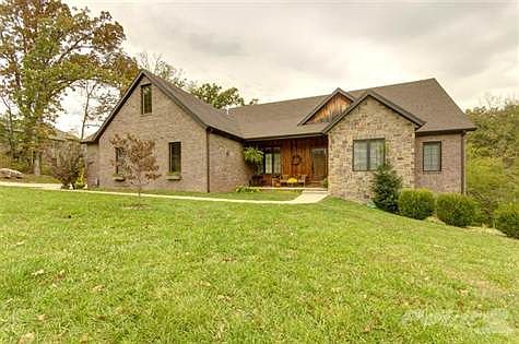 Front view of home resting on a beautiful, treed 1 acre lot