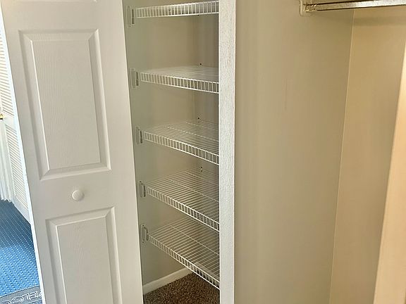 Entry hall, front door is open, 1 coat closet and 1 closet with shelves.