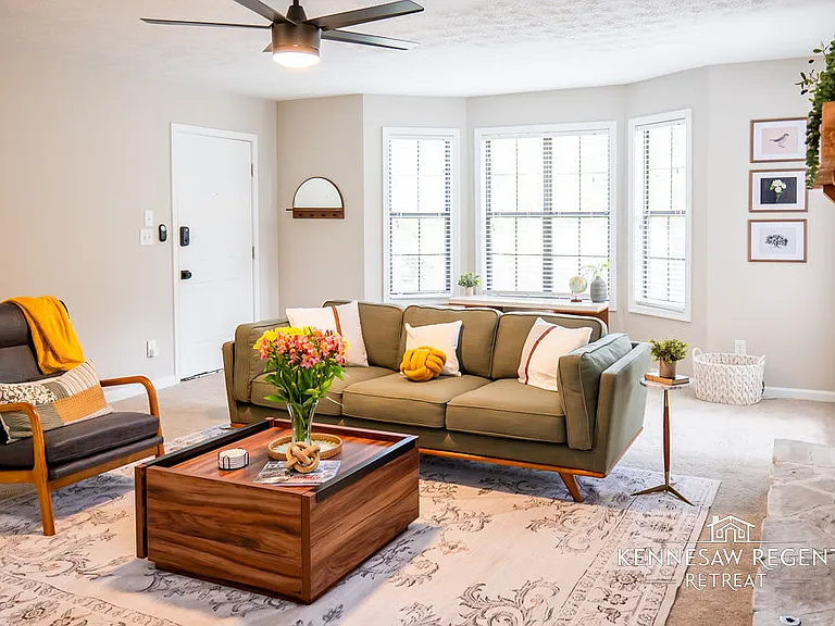 __The room's neutral color palette is accented by subtle pops of color, creating a sophisticated and inviting atmosphere. A sleek, modern fireplace adds a touch of warmth and ambiance to the space.