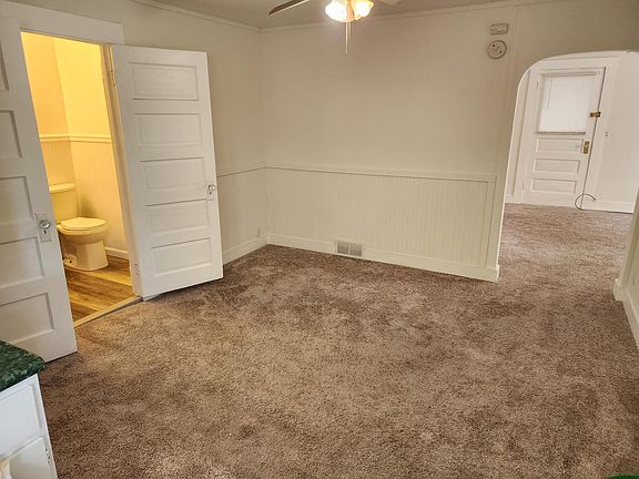 Dining Room. Door on left with light leads to bathroom. Arched doorway on right leads to Living room.