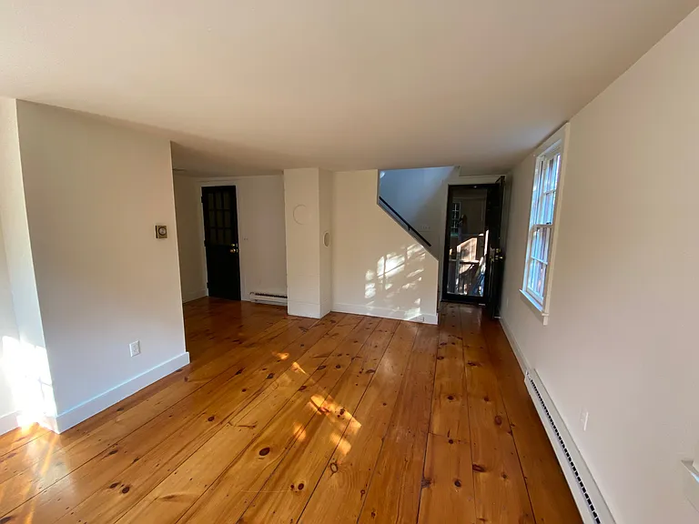 Living room. Door to left is from first floor staircase. Door to right leads to small covered porch and exterior staircase.