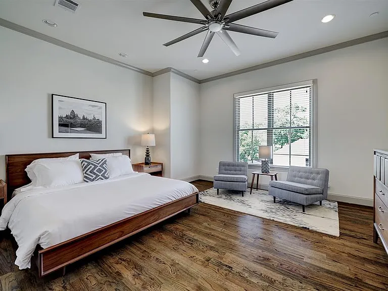 The expansive primary retreat includes hardwood floors, high ceilings (10"), space for a sitting area, recessed lighting, and an 8-blade ceiling fan with light.