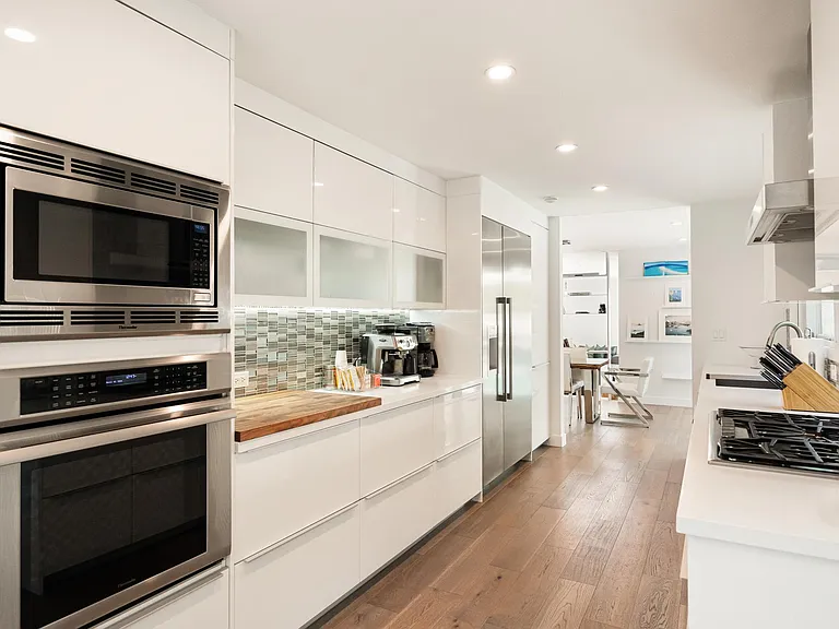 The sleek kitchen boasts top-of-the-line appliances and ample counter space.