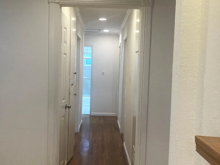 Hallway with hardwood floors leads to all 4 bedrooms, built in ceiling lights and storage cabinets