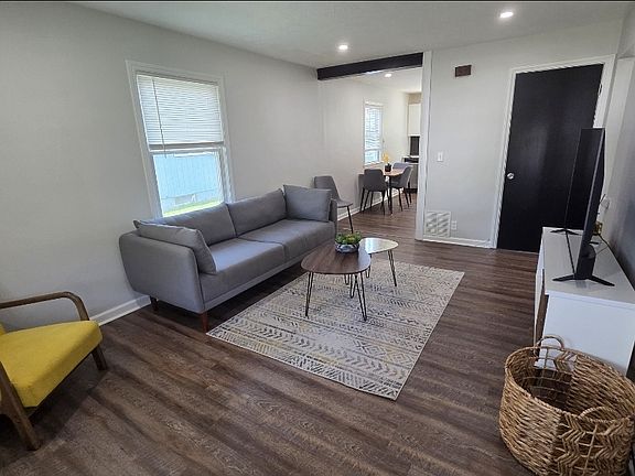Living room with couch, chair, entertainment center and TV!