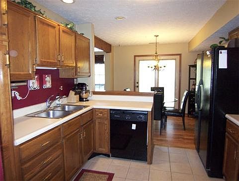 Bright kitchen featuring ceramic tile floors, smooth top cooktop stove, dishwasher & built-in microwave