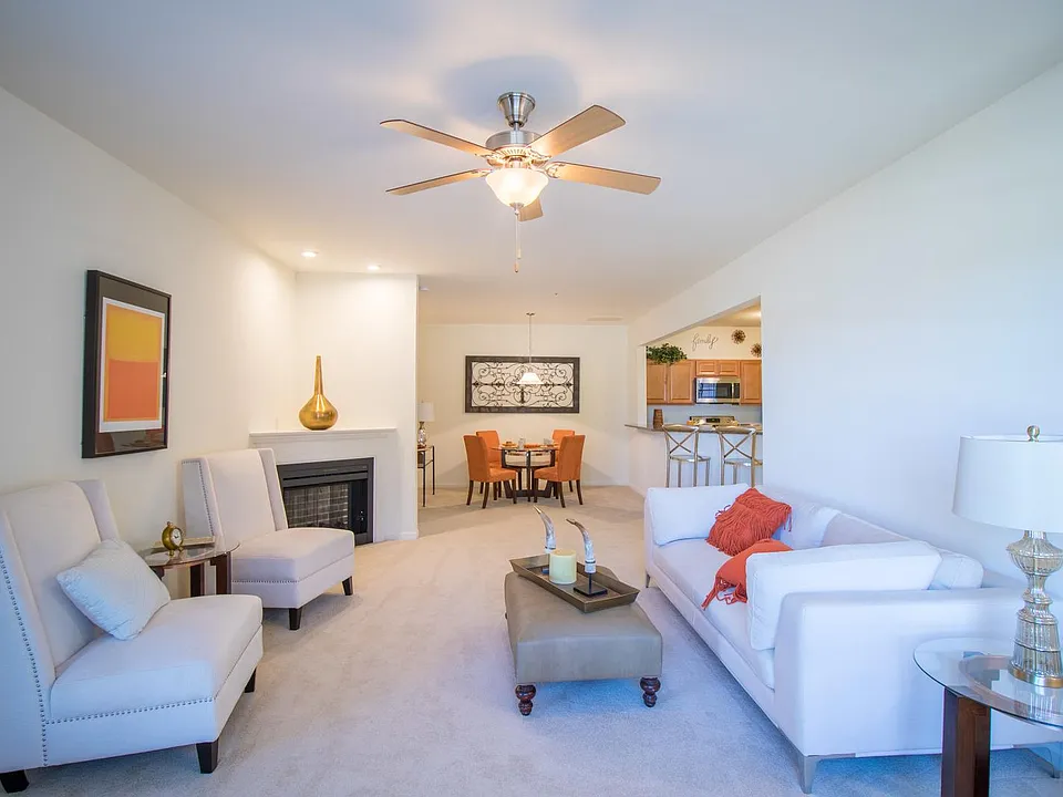 living room with corner fireplace, view to dining area