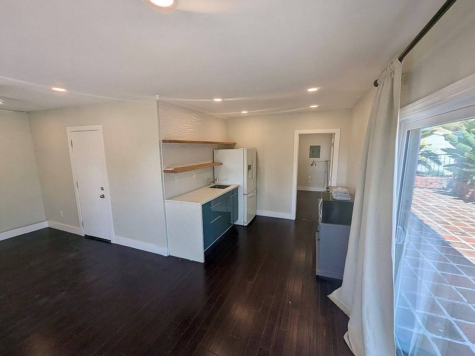 Standing in the dining/office area looking at the kitchenette on the right and living space on the left.
