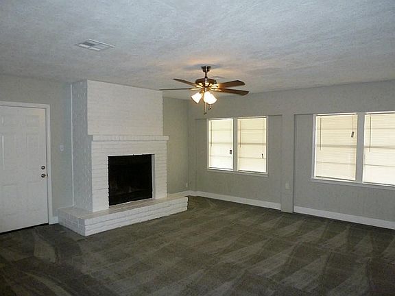 Garage converted into a family room with wood burning fireplace & celing fan